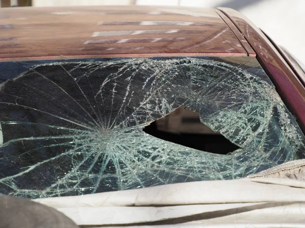 abandoned car after a crash with a broken windshield,