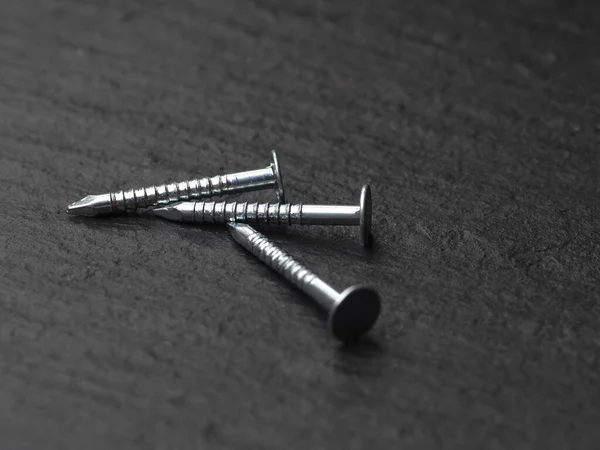 group of nails for assembling furniture on a black background