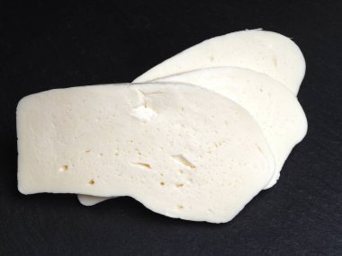 Siyah granit arka planda suluguni peyniri parçaları.