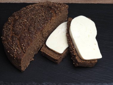 Malt üzerine Borodino ekmeği dilimleri ve mayasız ekşi ekmek ile sülüguni peyniri dilimleri.