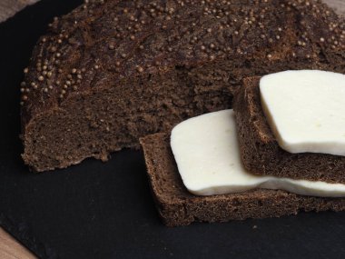 Malt üzerine Borodino ekmeği dilimleri ve mayasız ekşi ekmek ile sülüguni peyniri dilimleri.