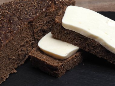 Malt üzerine Borodino ekmeği dilimleri ve mayasız ekşi ekmek ile sülüguni peyniri dilimleri.