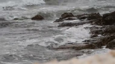 Deniz dalgaları kayalık bir kıyıya çarpıyor