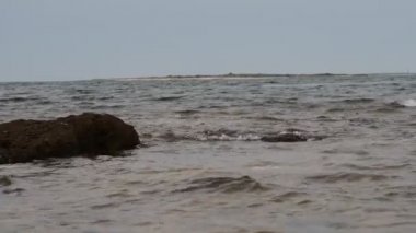 Deniz dalgaları kayalık bir kıyıya çarpıyor