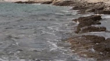 Deniz dalgaları kayalık bir kıyıya çarpıyor