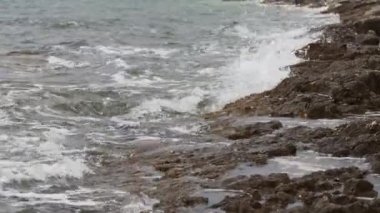 Deniz dalgaları kayalık bir kıyıya çarpıyor
