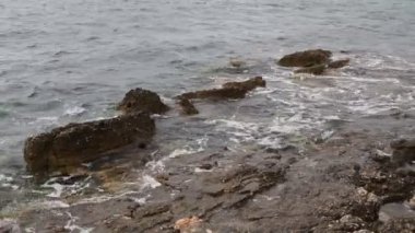 Deniz dalgaları kayalık bir kıyıya çarpıyor