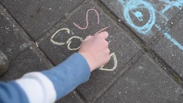 Childrens hand schrijft krijt op de asfaltvoet over de inscriptie covid — Stockvideo