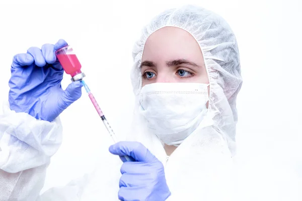Beyaz maskeli ve viral koruyucu giysili mavi lastik eldivenli bir virüs uzmanı kameraya korkunç bir şekilde bakıyor ve koronavirüs salgınını nasıl durduracağını ve ne yapacağını düşünüyor. Gözlerindeki korku....