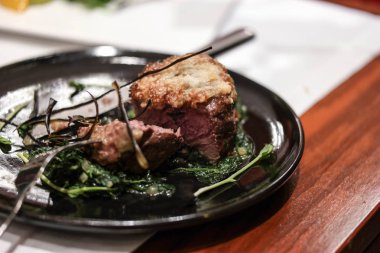 parmesan peyniri ve bir siyah plaka ıspanak fileto mignon biftek