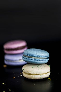 Macaroons koyu arka planda, renkli kurabiye macaroons Fransız. Bademli kurabiye. 
