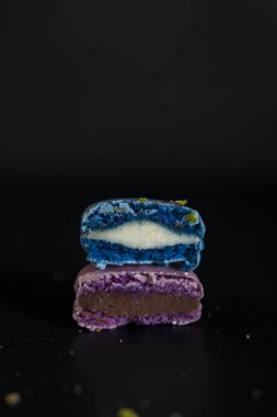 Macaroons koyu arka planda, renkli kurabiye macaroons Fransız. Bademli kurabiye. 