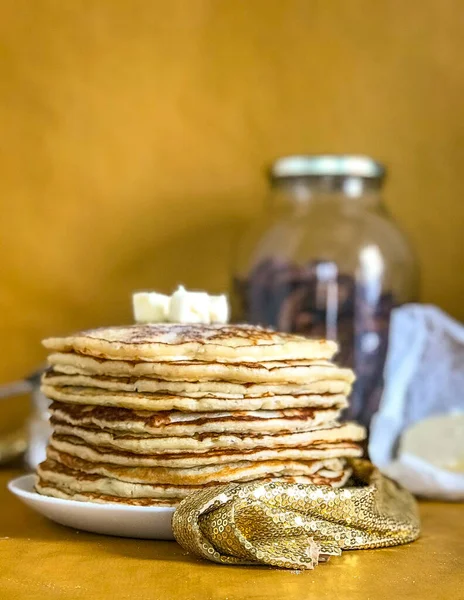 Beyaz tabakta ev yapımı krepler, sarı arka plan.