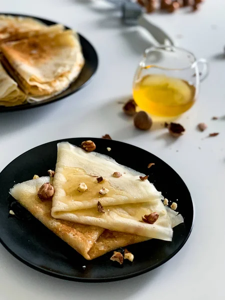 Palačinky Medem Ořechy Bílém Talíři Černých Mísách Domácí Tenké Palačinky — Stock fotografie