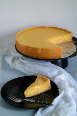 Siyah tabakta limonlu turta, bir dilim limonlu turta.