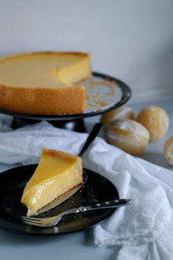 Siyah tabakta limonlu turta, bir dilim limonlu turta.