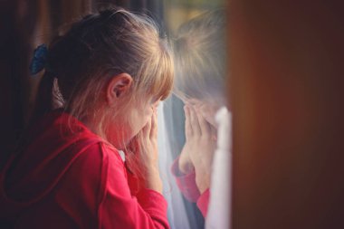 5 yaşında bir kız, trenin camından dışarı bakıp ağlıyor.