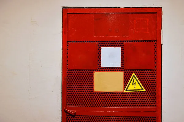 Die rote Tür mit dem Zeichen der Hochspannung lizenzfreie Stockfotos