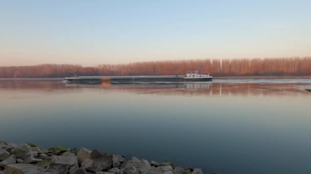 Barka płynie po wodzie wzdłuż Dunaju, rozdzielając Węgry i Słowację. Kamera obraca się powoli.. — Wideo stockowe