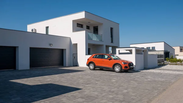 Gyor Macaristan 04 07 2020: Modern düz çatı evi. Önünde bir Audi Q3 arabası var. Emlak işi kavramı.