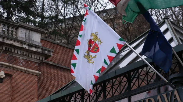 The coat of arms and flag of the city of budapest.