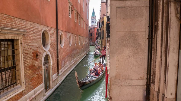 Venedik İtalya 08: 14: 2019: Gondol Venedik 'te bir kanaldan geçiyor. İlk gondolda yaşlı bir çift var..