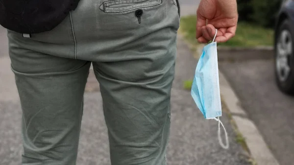 Bir adam elinde koruyucu bir maskeyle dolaşır. Koronavirüs mağazalarda giyilmesini zorunlu kılar..