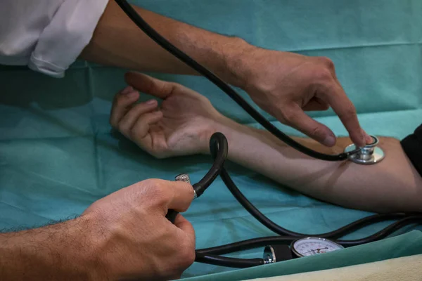 Krankenschwester nimmt Blutdruck des Patienten — Stockfoto