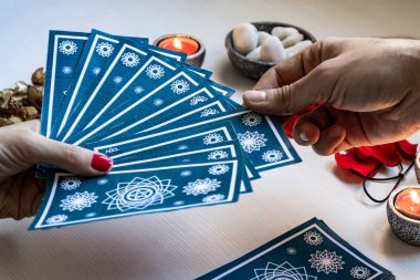 fortune teller with blue tarot cards on a white wooden table bac clipart