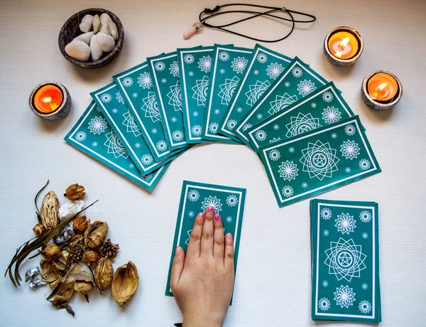 Chica adivina con cartas azules del tarot en una mesa de madera blanca — Foto de Stock