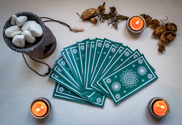 Tarjetas verdes del tarot con velas rojas en un respaldo de mesa de madera blanca — Foto de Stock