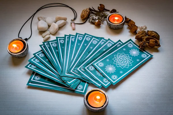 Cartes de tarot vert avec des bougies rouges sur un fond de table en bois blanc — Photo