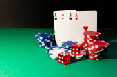 Karty, kostky a pokerové žetony na zeleném stole