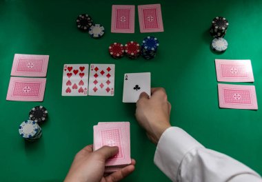 Bir adamın elleri bir tahtada poker kartları dağıtıyor.
