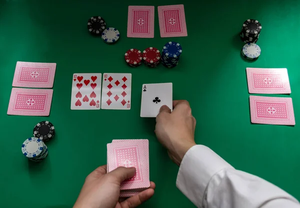 Las manos de un hombre reparten cartas de póquer en un tablero — Foto de Stock