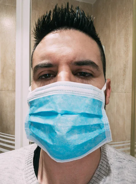 The new coronavirus of Wuhan (2019-nCoV), young man with blue medical mask — Stock Photo, Image