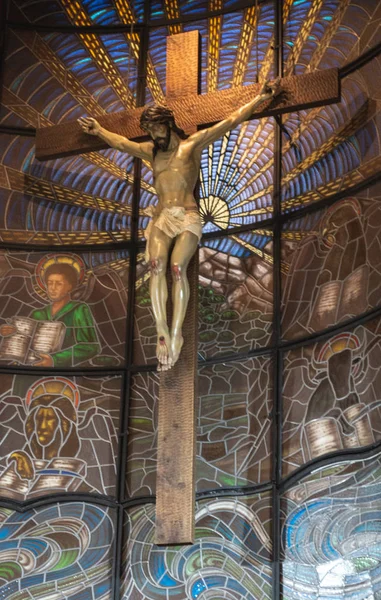 Jesuschristusstatue auf dem Kreuz vor Kirchenfenstern — Stockfoto