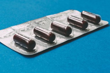 Mavi arka planda koyu kırmızı kapsüller. tıbbi konsept