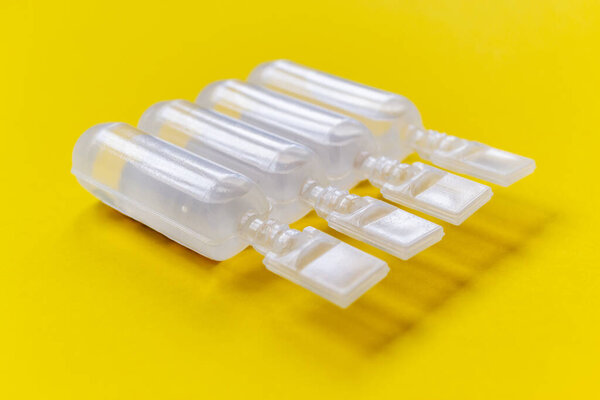 physiological serum ampoules on a yellow background. Nursing care