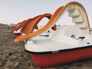 Sahilde park etmiş pedallı botlar. Tatildeki oyunlar