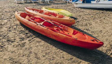 Kumsalda park etmiş sarı ve turuncu kanolar. yaz etkinliği