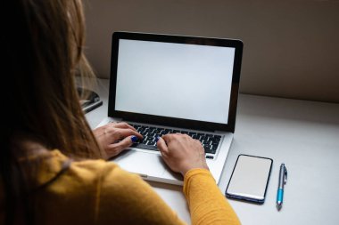 Evden, defterden ve beyaz ekranlı akıllı telefondan telgraf çeken bir kadın. Model için mükemmel resim