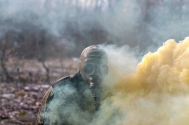 Gaz maskeli asker duman bombasıyla öldürülüyor.