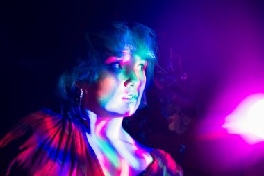 Çok renkli ışıkları olan bir kızın psikedelik portresi..