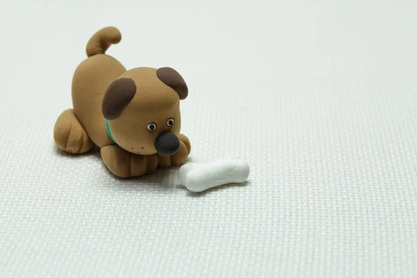 Hond uit plasticine en een bot — Stockfoto