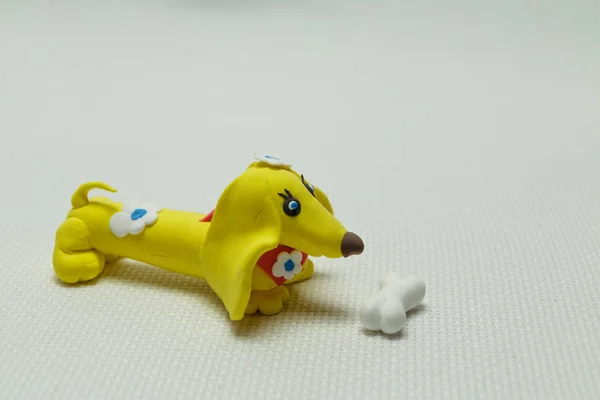 Hračka pes z plastelíny a kost — Stock fotografie
