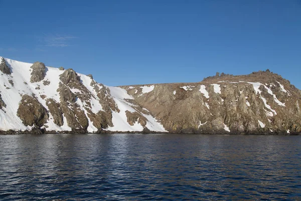 Wysoki morze skały w śniegu. — Zdjęcie stockowe