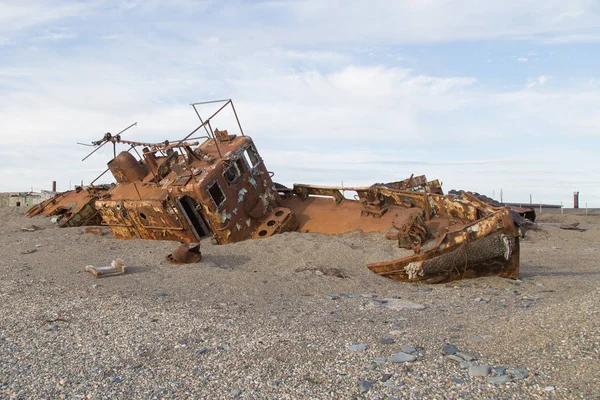 Old rusty boat in sand and a pebble