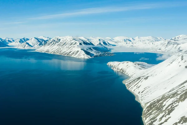 La costa del mar montañoso cubierto de nieve en un clima soleado . —  Fotos de Stock