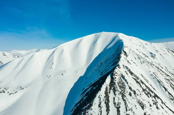 Hänge der schneebedeckten Berge bei sonnigem Wetter. — Stockfoto